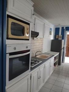 a kitchen with a microwave and a stove top oven at La vallée verte Martinique in Le Lamentin +1 photo