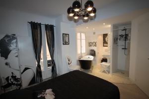 a bedroom with a black bed and a bathroom at From Hollywood to Bollywood 2 Bedrooms 2 Bathrooms - 1 min from Croisette&Beach, 12 Min from the Palais in Cannes