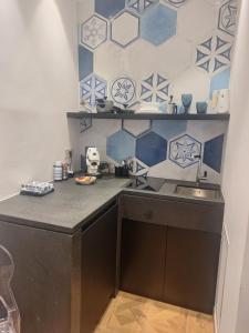 a kitchen with a sink and blue and white tiles at Suite Enea San Rocco in Sperlonga