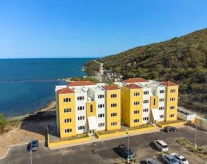 a yellow building on the side of the ocean at Deluxe suite in Portmore