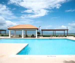 a swimming pool with a gazebo next to the ocean at Deluxe suite in Portmore