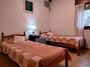 a room with two beds and a lamp and a window at Pinos del Virrey I in Valle Hermoso +59 photos