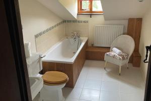 a bathroom with a tub and a toilet and a sink at 16th Century Devon Farmhouse Stunning Views in Winkleigh +69 photos