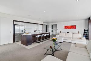 a living room with a couch and a kitchen at Tihi Retreat in Rotorua