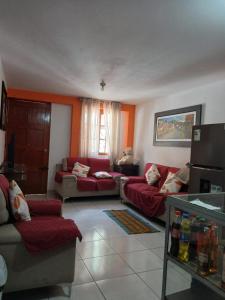 a living room with two couches and a red couch at La Posada del Inca Chavin in Chavín de Huantar