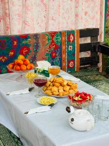 a table with plates of food and bowls of fruit at Maximus in Bokonbayevo