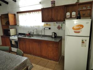 a kitchen with a white refrigerator and a sink at Pinos del Virrey I in Valle Hermoso
