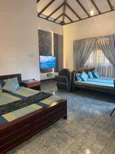 a hotel room with two beds and a tv at Natures Bliss Holidays in Ja-Ela +281 photos