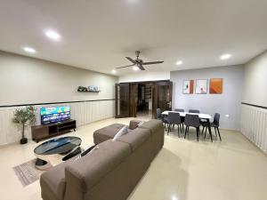 a living room with a couch and a dining room at YOLO4 4BR 16PAX CentralTown Netflix in Kuantan