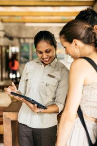 a woman standing next to a man holding a tablet at Cinnamon Wild Yala in Yala