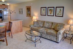 a living room with a couch and tables and a kitchen at Hale Kai O'Kihei 219 in Kihei