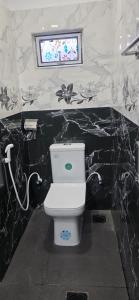 a bathroom with a toilet with black and white marble walls at SK Guest House in Jaffna