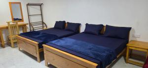 a bedroom with two beds and a desk and a mirror at SK Guest House in Jaffna