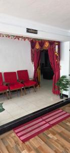 a room with red chairs and red curtains at SK Guest House in Jaffna