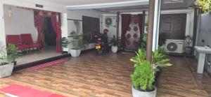 a living room with potted plants on a wooden floor at SK Guest House in Jaffna