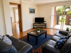 a living room with a couch and a coffee table at Quaint Hideaway in Portarlington