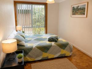 a bedroom with a bed and a window at Quaint Hideaway in Portarlington