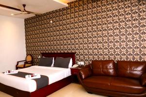 a bedroom with a bed and a leather chair at Hotel Sree7 Inn in George Town
