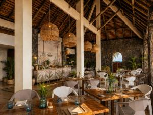 a restaurant with wooden tables and chairs and chandeliers at Lankraz Hotel Mauritius in Port Louis