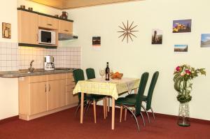 eine Küche mit einem Tisch und grünen Stühlen sowie eine Küche mit einer Spüle in der Unterkunft Ferienwohnung Henker in Bad Schandau