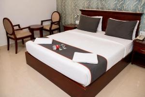 a bedroom with a large bed with two chairs at Hotel Sree7 Inn in George Town +6 photos