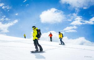 a group of people skiing down a snow covered slope at Refugio de montaña Küme Mongüen in Malalcahuello