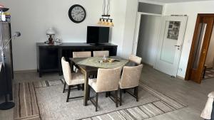 a dining room table with chairs and a clock on the wall at Ferienwohnung Menzel in Gedern