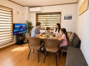 a family sitting around a dining room table at Villa Lotus in Kamakura