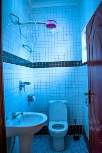 a blue tiled bathroom with a toilet and a sink at theSuperblane Resort in Sagana +17 photos