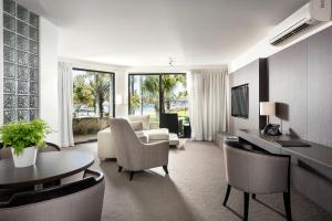 a living room with a couch and a table at Pier 21 Riverside Apartment Hotel in Fremantle