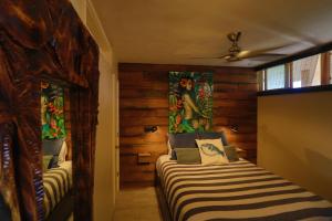 a bedroom with two beds in a room with wooden walls at Hale Kai O'Kihei 310 in Kihei