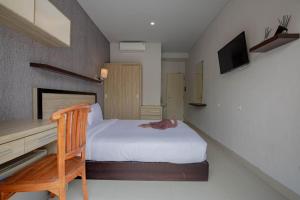 a small room with a bed and a desk and a desk at Lushy Hostel Canggu in Canggu