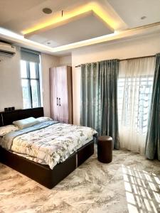 a bedroom with a large bed and large windows at Modern getaway in Ajah in Lekki