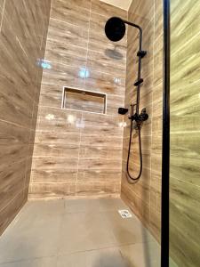 a shower in a bathroom with a wooden wall at Modern getaway in Ajah in Lekki +38 photos