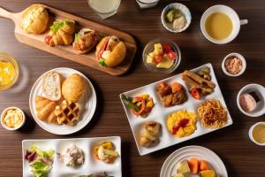 a wooden table with plates of food on it at Hotel Vista Matsuyama in Matsuyama