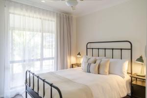 a bedroom with a bed and a large window at Narrawallee Nirvana in Narrawallee
