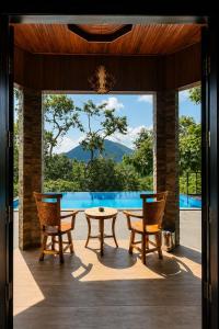 a patio with a table and chairs and a pool at de Bintan Villa in Tenaga
