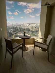 a table and chairs in a room with a large window at Grand Museum with Pyramids view inn in Cairo