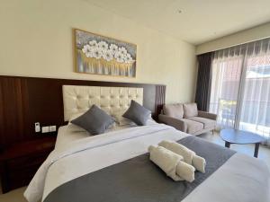 a bedroom with a large bed and a couch at Taman Agung Hotel in Sanur