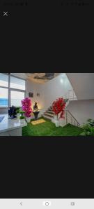 a living room with stairs and flowers in pots at New Stay Hotel in Gurgaon +2 photos