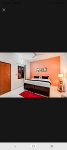 a bedroom with a bed with an orange wall at New Stay Hotel in Gurgaon