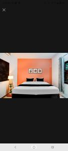 a bedroom with a large bed with an orange headboard at New Stay Hotel in Gurgaon