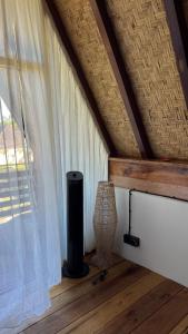 a room with a window and a vase on a wooden floor at Mango Garden Villas in Sekongkang Bawa