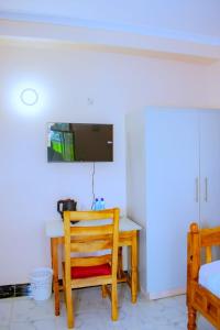 a room with a desk with a chair and a tv at theSuperblane Resort in Sagana