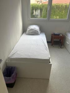 a small bed in a room with two windows at residence st marguerite in Antibes