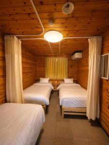 a room with four beds in a log cabin at Meteor Garden in Hakuba