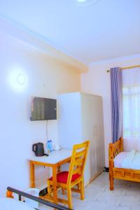 a room with a table and chairs and a couch at theSuperblane Resort in Sagana