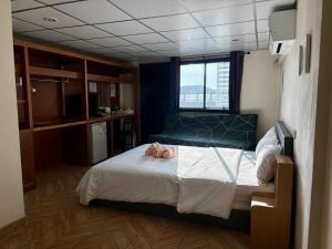 a bedroom with a bed with a teddy bear on it at Double D Rooms & Cafe in Bangkok