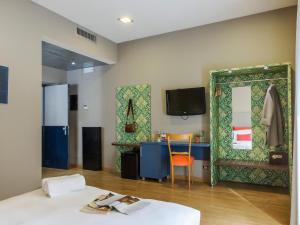 Habitación con cama, mesa y espejo. en Monti First, en Roma