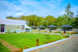 a white building with a grassy yard in front of it at theSuperblane Resort in Sagana